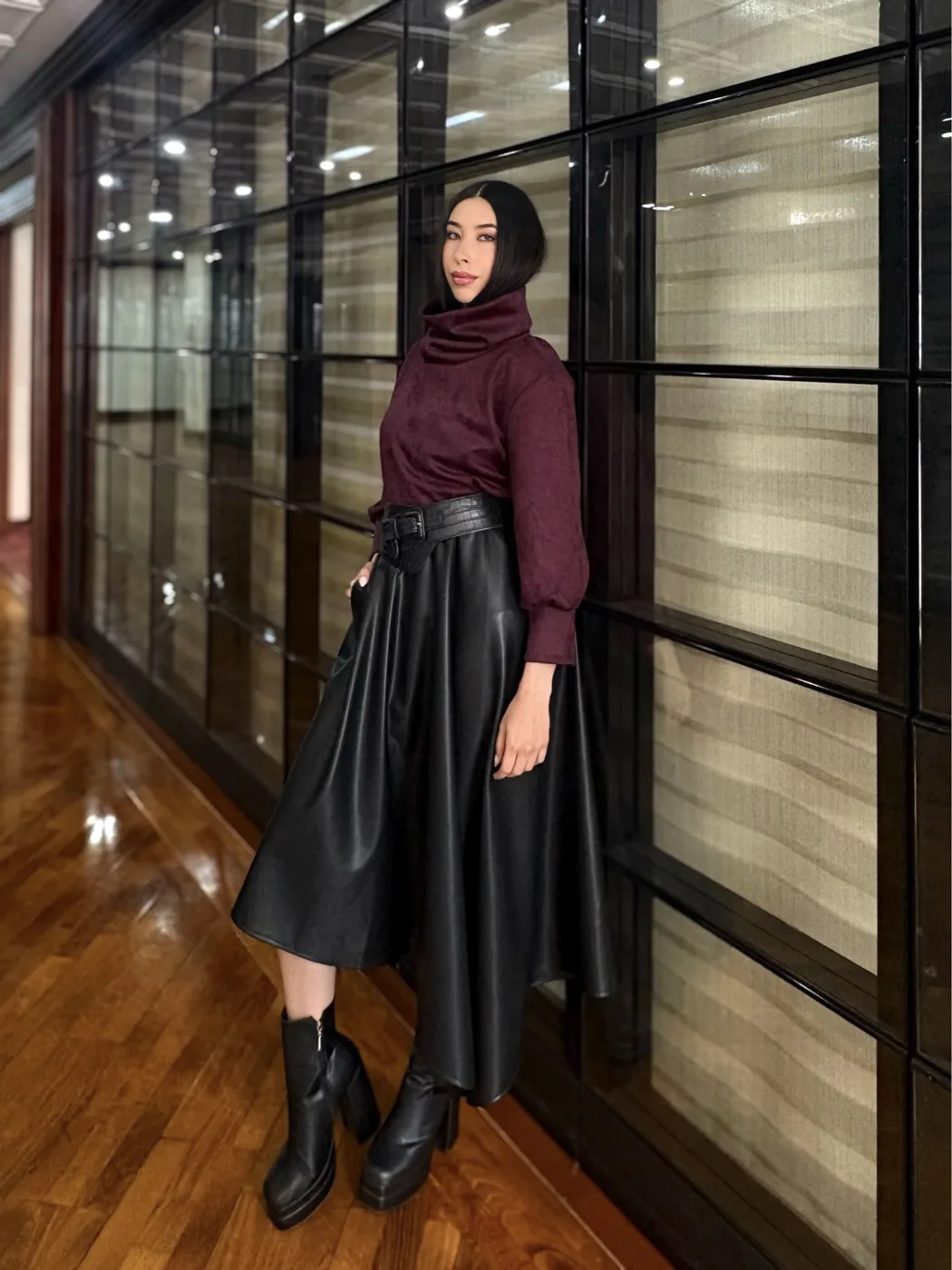 Modelo con blusa vino y falda en cuero sintético